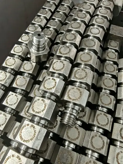 Rows of marked machined components with threaded ends