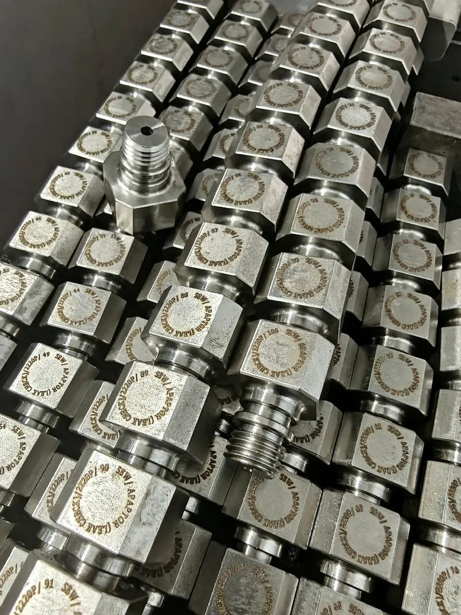 Rows of marked machined components with threaded ends