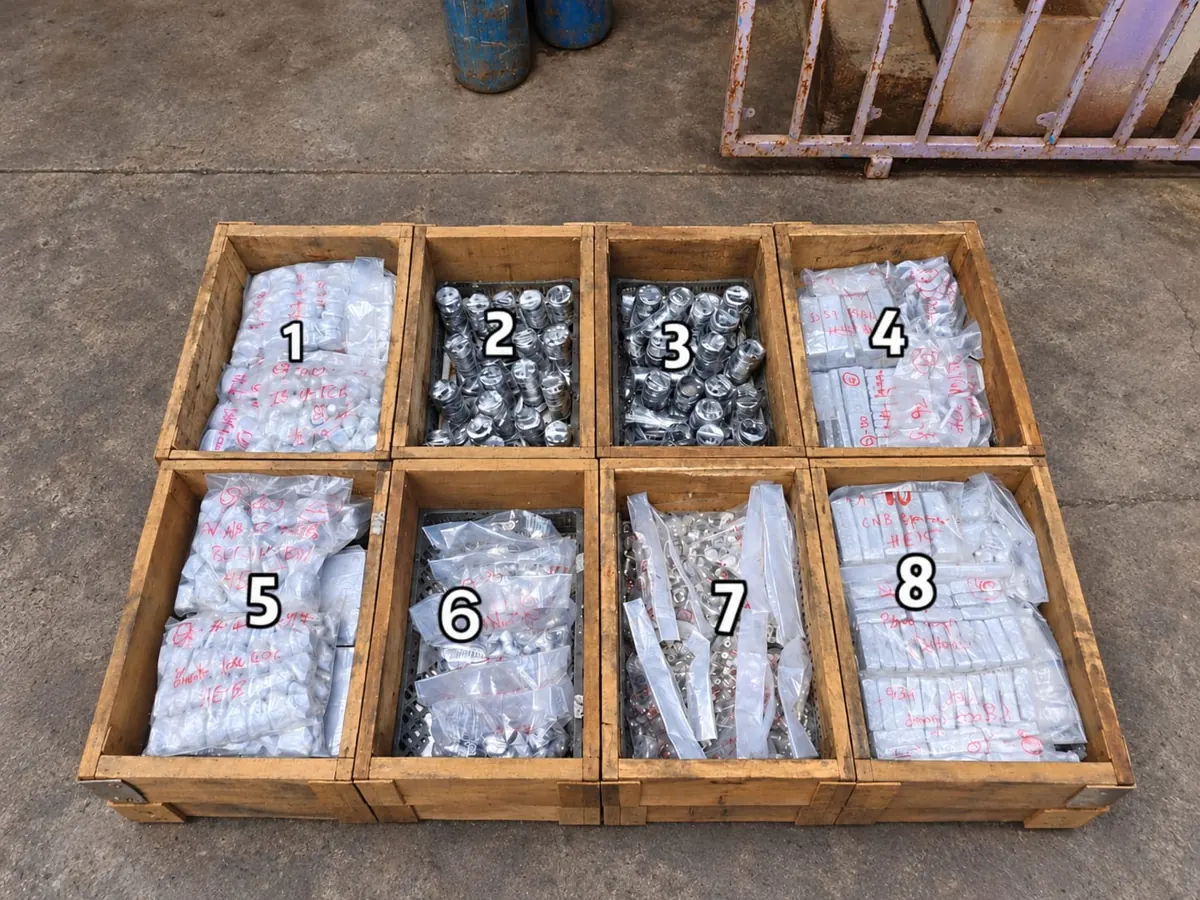 Open wooden crate with numbered compartments holding bagged and separated components