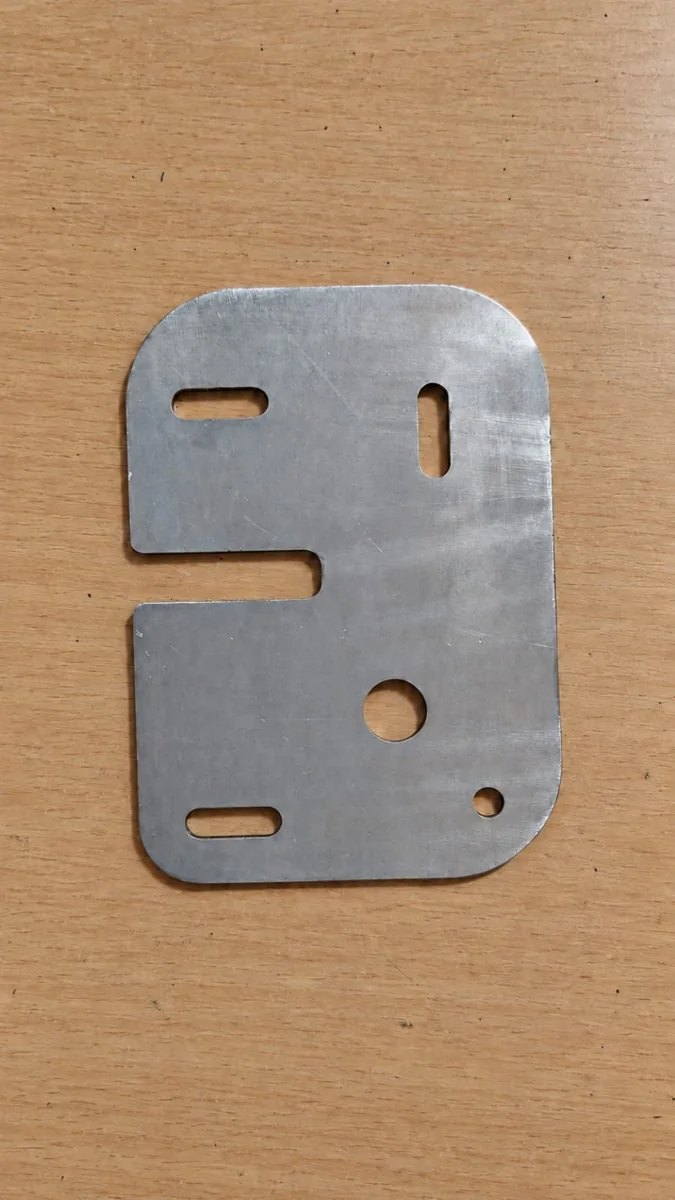 Laser-cut metal plate with slots, round holes and a side opening